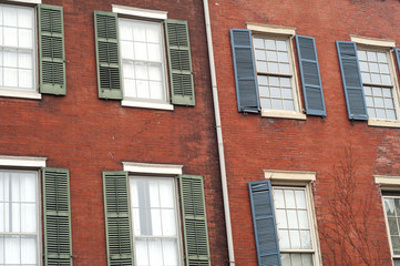 Fototapeta na wymiar Urban house brick wall facade with windows with open shutters