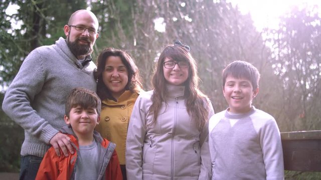 Portrait of a latin family standing on a bridge and smiling