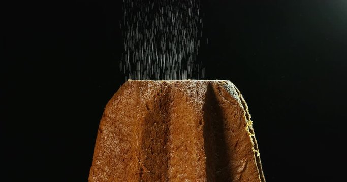 close up of a Pandoro, a typical Italian pastry eaten during the Christmas holidays and the New Year, The powdered sugar falls in slow motion on Pandora creating the Christmas magic.