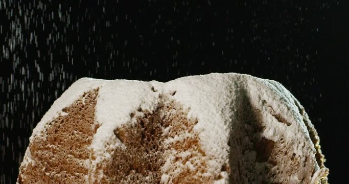 close up of a Pandoro, a typical Italian pastry eaten during the Christmas holidays and the New Year, The powdered sugar falls in slow motion on Pandora creating the Christmas magic.