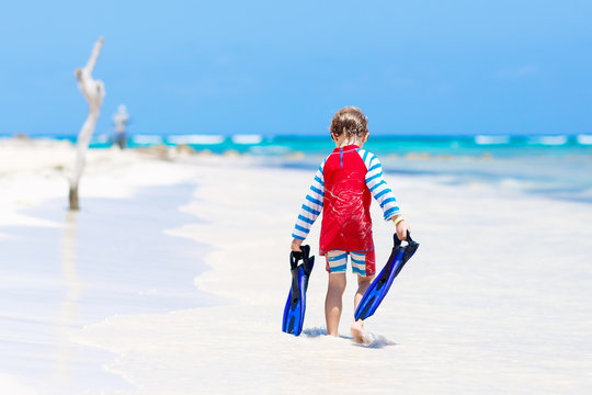 little blond kid boy having fun on tropical beach of Maldives