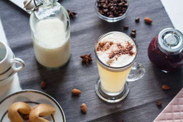 Latte with purple jam on a gray tablecloth