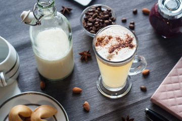 Latte with purple jam and milk on a gray tablecloth