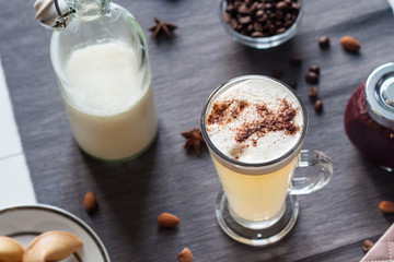 Latte with purple jam on a gray tablecloth