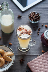 Morning latte with purple jam on a gray tablecloth