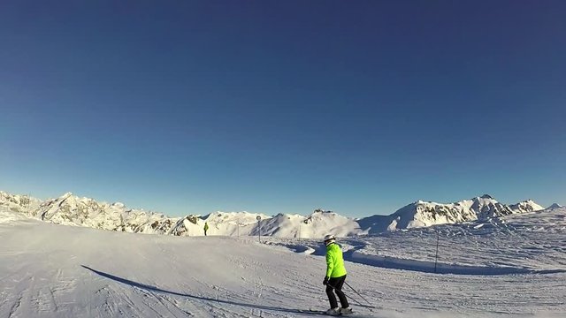 Slow motion: Young woman is skiing down on slope on sunny day, Tignes, France