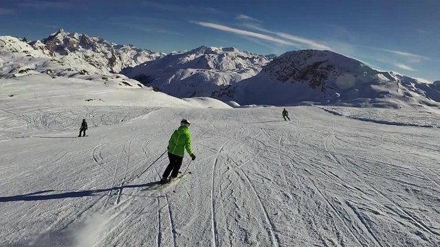 Slow motion: Young woman is skiing down on slope on sunny day, Tignes, France