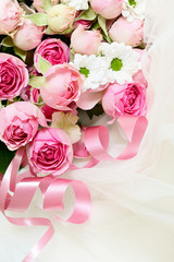 Pink rose flowers and ribbons on veil