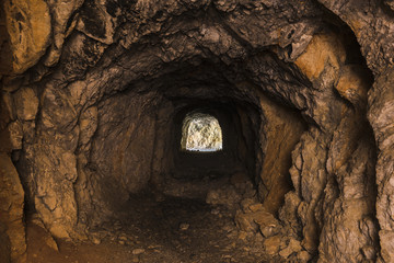 Interno di una cava buia con l'uscita illumina in vista in fondo