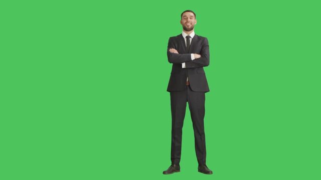 Long Shot of a Handsome Businessman Crossing His Arms on a Chest and Smiling. Background is Green Screen.  Shot on RED Cinema Camera 4K (UHD).