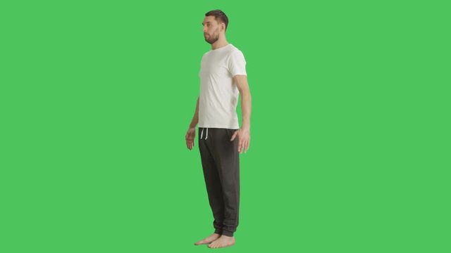 Long Shot of a Bare Foot Man Wearing T-Shirt and Sweatpants while Camera Rotates Around Him. Shot on a Green Screen Background.  Shot on RED Cinema Camera 4K (UHD).