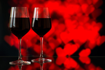 Two glasses of red wine against bokeh background with sparkles a