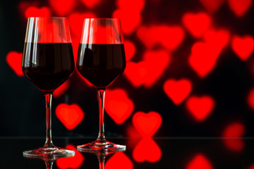 Two glasses of red wine against bokeh background with sparkles a