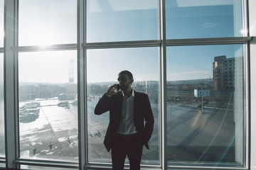 Fototapeta premium Business man speak phone against panoramic windows