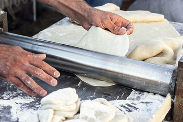 Chef making dough pastry sheeter at bakery Baker forming shaping dough rolled pastry metal work...