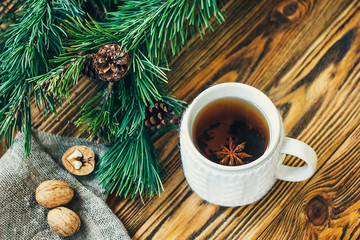 Christmas New Year composition winter holiday celebration concept symbol tangerines clementine nuts pine cones fir branches cup tea rustic style old wooden board selective focus festive greeting card