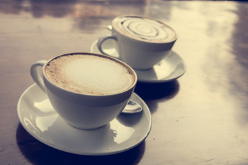 Two cups of coffe on wooden table.