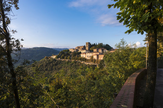 Scorcio tra gli alberi del borgo medievale di Montecatini Alto al tramonto.