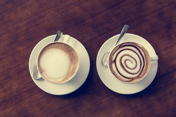 Two cups of coffe on wooden table.