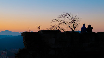 Friends silhouette at sunset over the top of Ljubljana Castle (Slovenia)