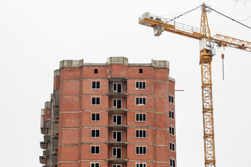 The construction of multi-storey houses of red brick. Crane