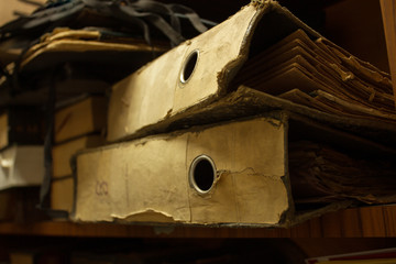 Dusty old stack of papers and files in archive room of office