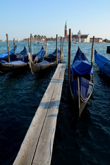 Fototapeta na wymiar Gondolas at wooden pier in Venice in Italy
