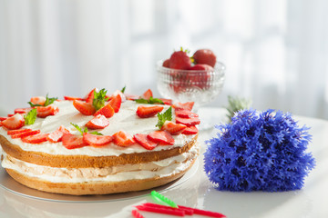 strawberry cake on white tablie near the window