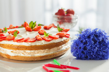 strawberry cake on white tablie near the window
