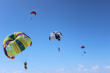 Colorful parachute landing on stormy sky.