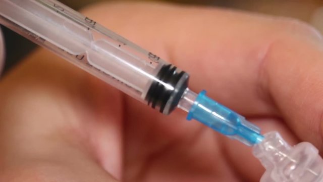 Syringe taking a liquid  medicament from capsule.