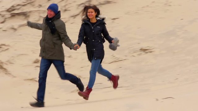 Attractive couple having fun being together running on the beach.