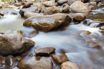 Natural rocks over the flowing clear water.