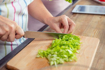 Woman cutting salad greens