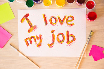 The inscription on a white sheet, "I love my job" in bright colors