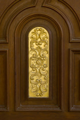 teak wood door with gold carving.