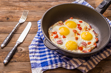 Fred eggs in pan with tomatoes.