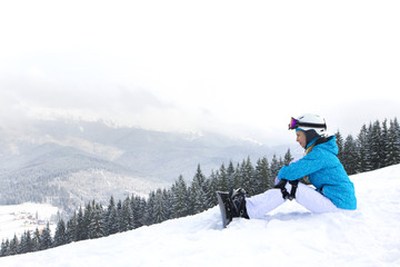 Fototapeta na wymiar Beautiful Young Woman Sitting on Mountain Snow.