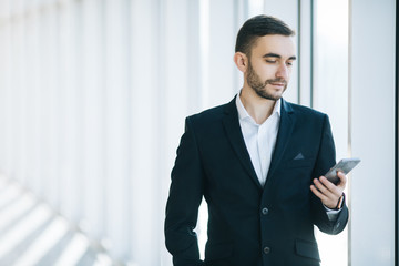 Handsome businessman in suit look at smartphone in office