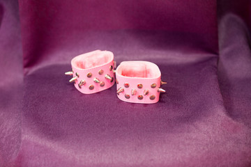 pink handcuffs with thorns lie on a table