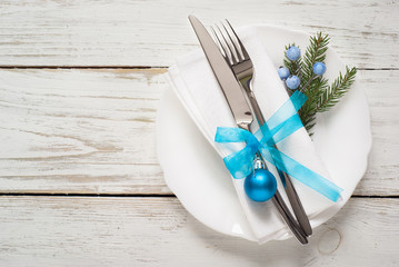 Christmas table setting with decorations on white.