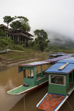 Foggy Mekong river bank with two wooden boats