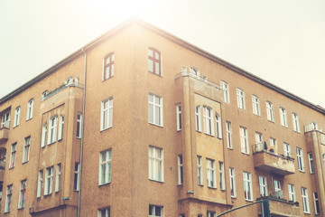 Fototapeta premium old corner house in sunlight with ddr facade