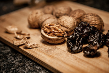 Walnuts nad dried prune on the wooden board for men's health