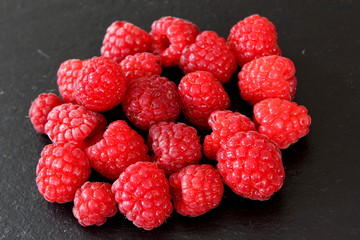 red raspberry fruits  on a slate plate