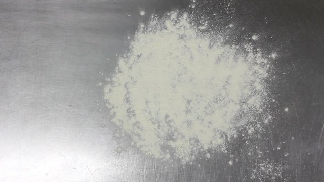 Baker throwing flour and dough on the table