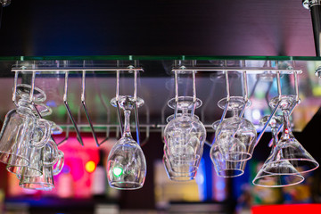 glasses in shelf above a bar rack