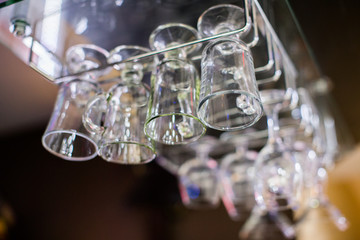 glasses in shelf above a bar rack