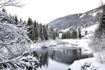Verschneite Winterlandschaft mit Bach im Ultental