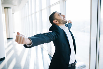 excited young caucasian businessman celebrate victory cheerful in modern office